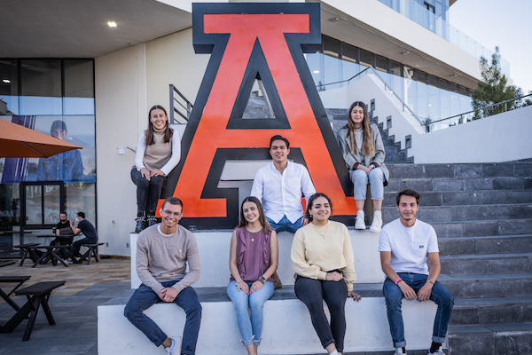 Estudiantes de la anahuac puebla sentados frente a una escultura