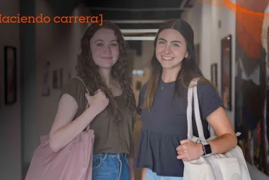 Par de estudiantes de la Red de Universidades Anáhuac sonriendo en pasillos del campus