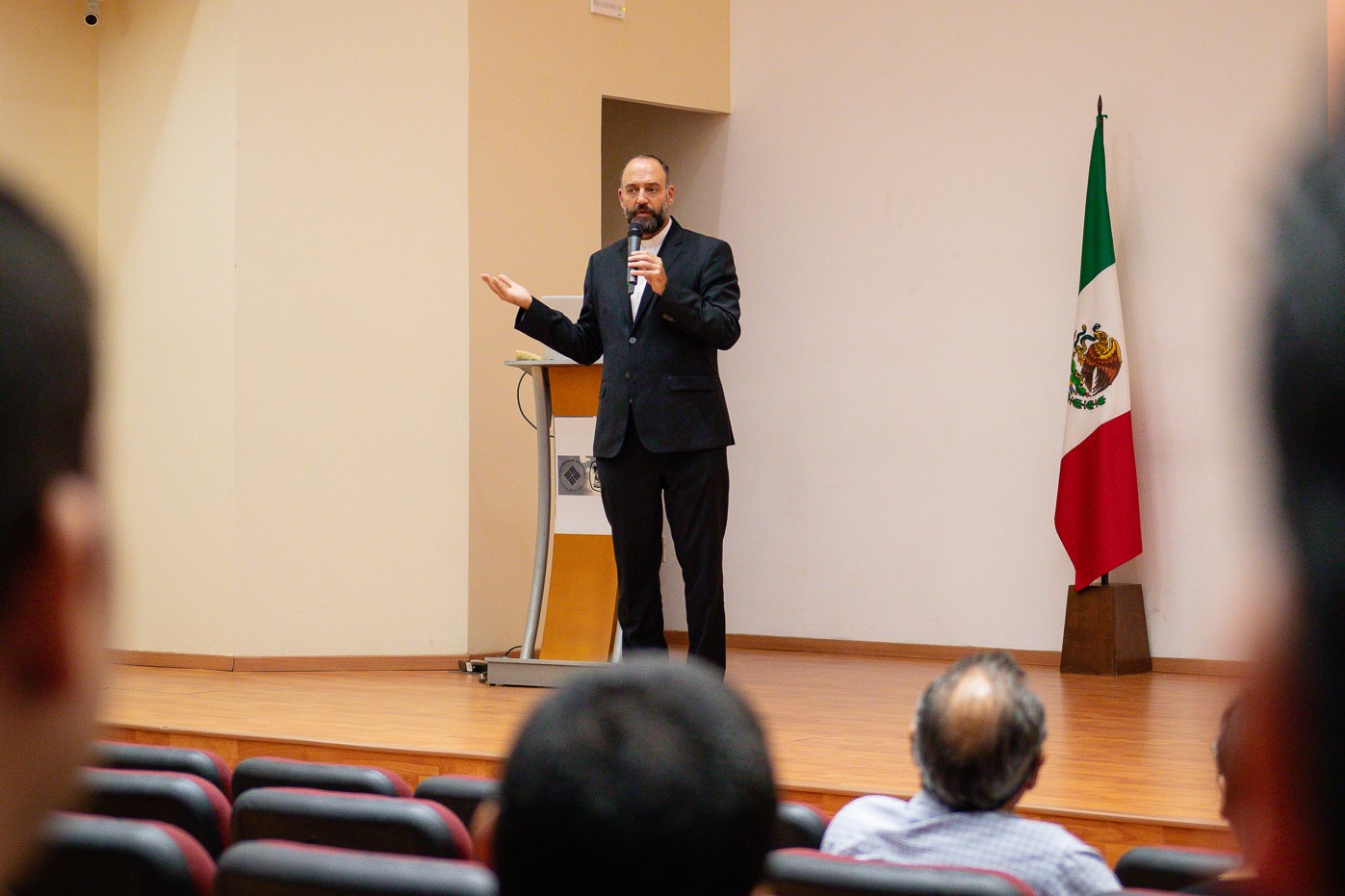 Padre Manuel Cevallos hablando ante un público en el auditorio Mtro. David Gómez.